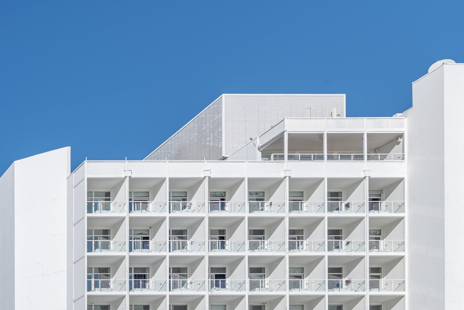 a tall white building with balconies and balconies